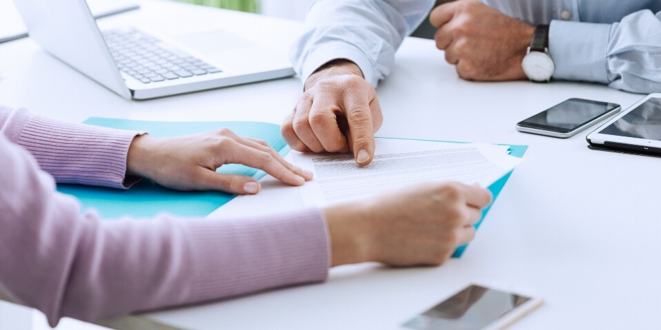 CF Motgages Soliciters Image | Image of a group of people sat at a desk explaining paperwork